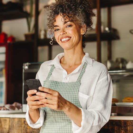 A business owner holding a cellphone